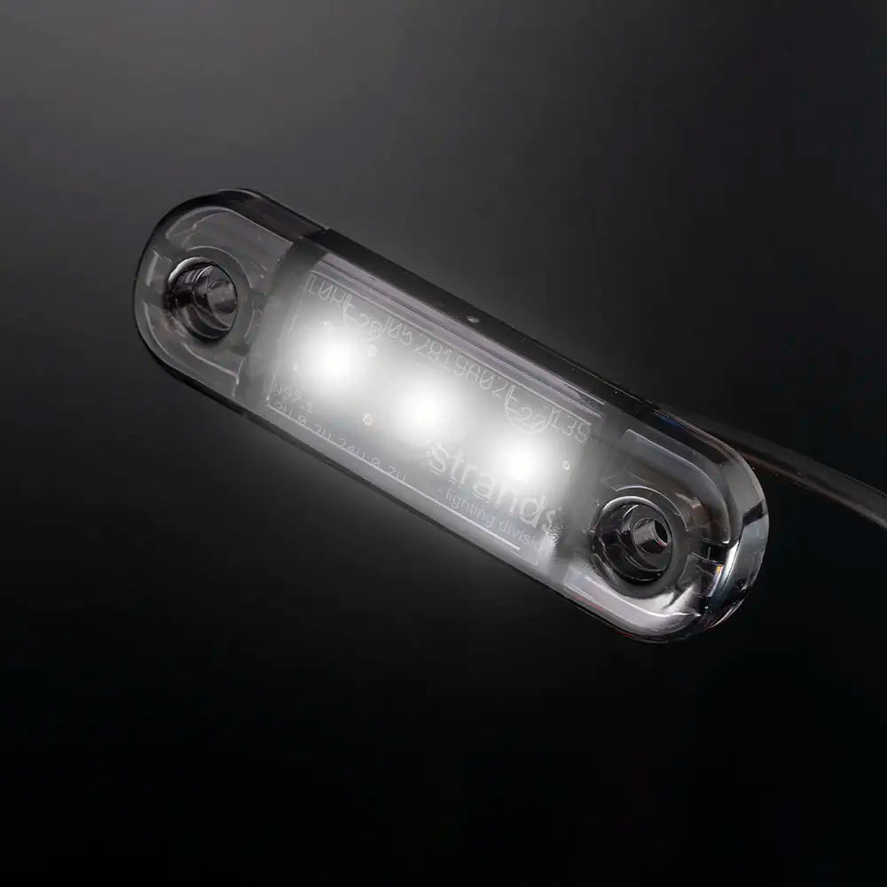 Mustalla taustalla loistava kapea LED-äärivalo, jonka kolme valkoista valonlähdettä loistavat kirkkaasti.