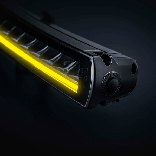Musta Strands Siberia XP SRC LED BAR 22" -lisävalopaneeli etuviistosta läheltä kuvattuna tummalla taustalla. Valon alaosassa keltainen LED-parkkivalonauha ja valossa yksirivinen heijastinratkaisu.